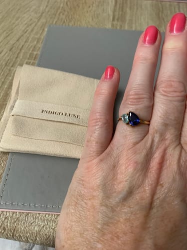 Customer wearing the Leesha Birthstone Ring with a sapphire and an aquamarine stone on a gold band.