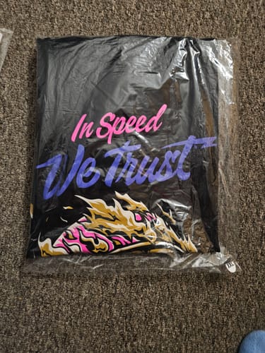 Reviewer's WILD TIMES TEE folded in its original plastic packaging, showing the colorful graphic print.