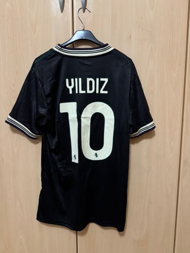 Recensore mostra il retro della maglia third nera della Juventus personalizzata con il nome YILDIZ e il numero 10.