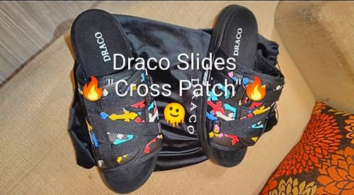Reviewer's black Cross Patch DracoSlides with colorful patches on the straps, shown with a black satin storage bag.