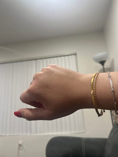 Reviewer showing the gold Selene Snake & Bead Chain Bracelet on their wrist indoors.