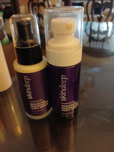 Close-up of a reviewer's two Bakuchiol Resurfacing Night Serum bottles with their pumps visible.