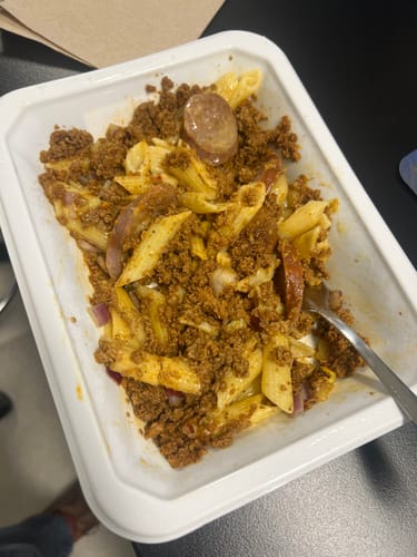 Close-up of a customer's prepared Beast Mac in its container, showing pasta, ground meat, and sausage.