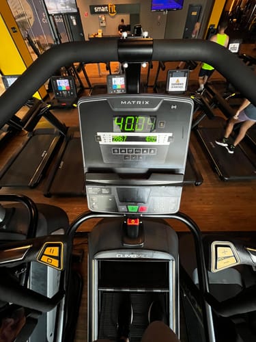 Cliente em um aparelho de ginástica em uma academia, no contexto de sua avaliação do Kit Pele Uniforme.