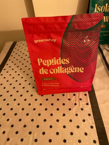 Le sachet rouge des Peptides de Collagène au chocolat, photographié par un client sur une table.