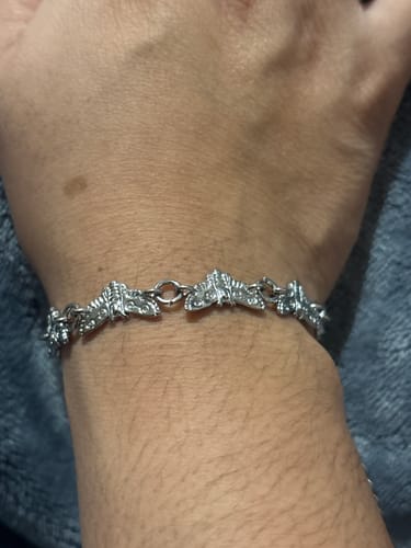 Customer's wrist wearing the MOTH BRACELET, showing the linked silver moth design.