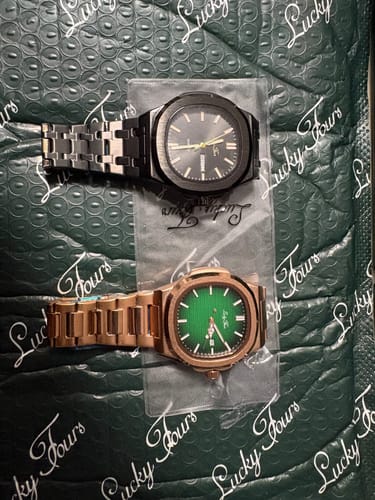 Customer's two Lucky Fours® Wraith watches, one black and one rose gold, in plastic sleeves on branded packaging.