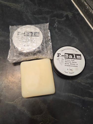 Customer's Tallowed Truth Bar soap next to two tins of tallow balm on a dark counter.