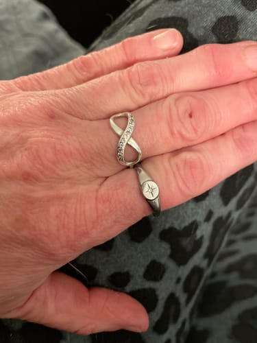 Reviewer's hand wearing the silver North Star Signet Ring stacked with another ring.