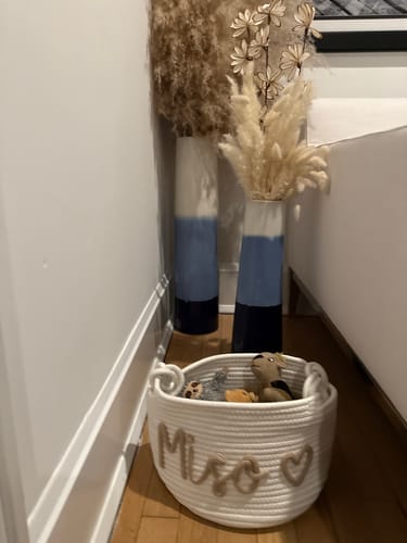 Customer's white Personalized Knitted Basket with the name Miso and a heart, filled with toys on a floor.