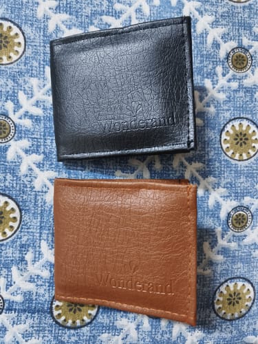Customer's received wallets, showing a black and a brown wallet on a patterned blue cloth background.