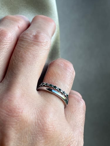 Customer's hand wearing the Silver Marissa Emerald Green Layered Ring with green cubic zirconia