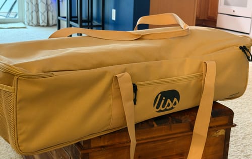 Customer's tan carrying case for The Go Hammock, sitting on a wooden surface.