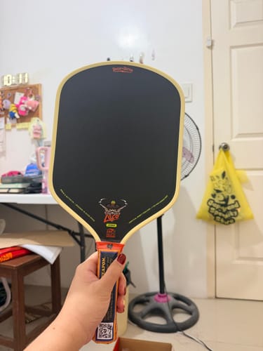 Customer's hand holding a Loco 16mm Pickleball Paddle Hybrid, showing the black face and colorful handle