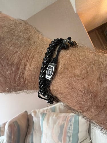 Customer's black Black Mamba Bracelet worn on wrist, featuring a metallic clasp with etched lettering.