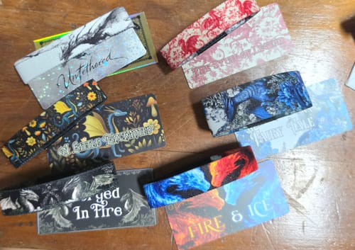 Reviewer's Legacy Mystery Club+ bracelets laid out on wood, showcasing dragon designs like Fire & Ice and Untethered.