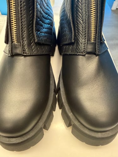 Customer's black Emerald ankle boots showing a close-up of the front, thick lug soles, and gold zippered front.
