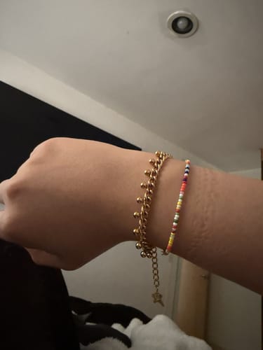 Customer's Chelseapulsera, a gold chain bracelet with small decorative orbs worn on a person's wrist.
