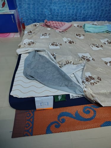 Customer's Flo Mattress Ergo with a floral bed sheet pulled back to show the internal memory foam layer