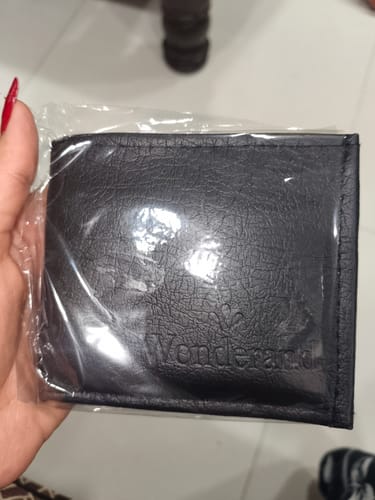 Customer's black Spiderman wallet held in a hand, inside clear plastic packaging.