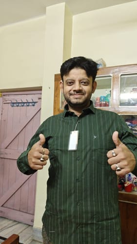 Customer's green striped shirt with a spread collar worn by a person giving a thumbs up.