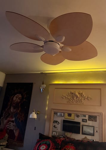 Customer's Dahlia ceiling fan with light wood petals mounted in a bedroom with ambient lighting.