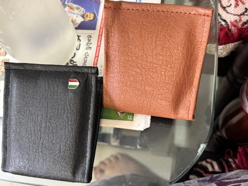 Customer's two wallets, one black and one brown, sitting on a glass surface.