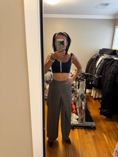 Customer's grey pinstripe wide-leg pants with wrap-effect front and buckle belt, worn in a room.