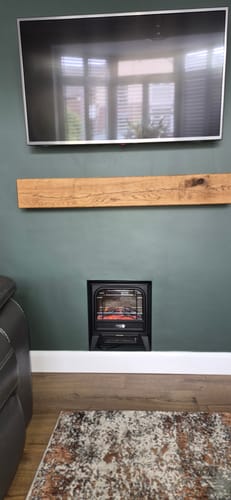 Customer's Rustic Oak Fireplace Beam installed as a floating mantel above a fireplace with a TV mounted above it.