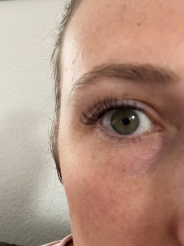 Reviewer zeigt nach Anwendung des TOOLBOX-Sets natürlich wirkende Wimpern am Auge.