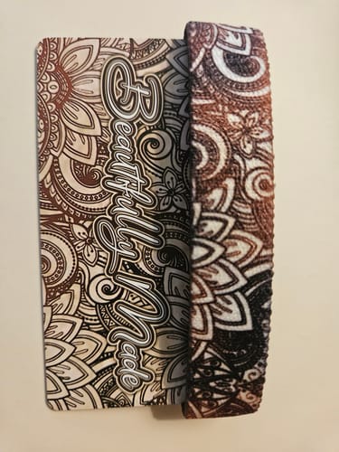 Reviewer's Beautifully Made bracelet beside its matching floral display card with brown mandala-style artwork.