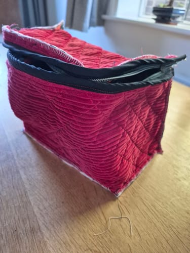 Reviewer's project using Jumbo Washed Corduroy Fabric, a red quilted pouch with a black zipper on a wooden table.