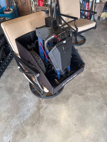 Customer's Cyber Trunk Case, black and folded, resting on a beige chair in a garage.