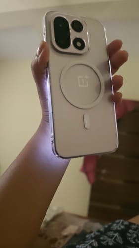 Customer's hand holding a clear Anti Yellow Magsafe Clear Case for OnePlus 15 with visible MagSafe ring on back.