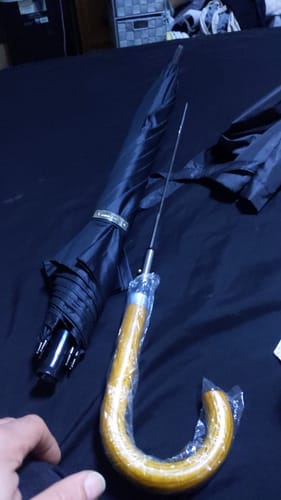 Customer's Hidden Sword Umbrella with the black canopy closed and the wooden handle opened to reveal the thin metal blade.