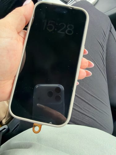 Reviewer's iPhone with 3 in 1 Schutzfolie held in hand, showing visible damage at the edges.