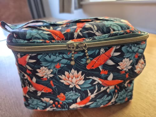 Customer's makeup bag made from Floating Garden Rose & Hubble cotton fabric, featuring koi fish and floral patterns.