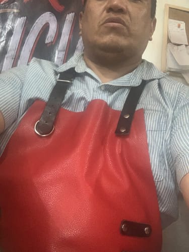 Customer's Mandil Parrillero Mosvarti Tomahawk in red leather being worn over a light blue striped shirt.