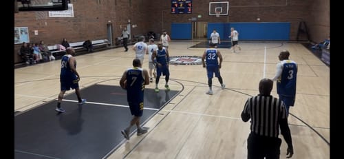Customer's navy and white basketball jerseys worn by players during a game on an indoor court.