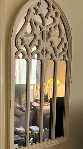 Customer's distressed white Daniel French Provincial Arch Mirror mounted on a wall.