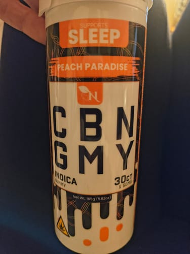 Customer's container of Peach Paradise CBN Gummies, showing the product name, branding, and sleep-focused packaging.