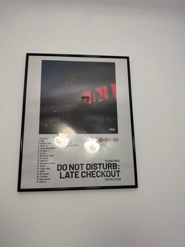 Customer's framed DO NOT DISTURB: LATE CHECKOUT music poster hanging on a white wall.