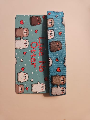Customer's blue Unreleased Bracelet featuring cute otter illustrations and a matching card that says Like No Otter.