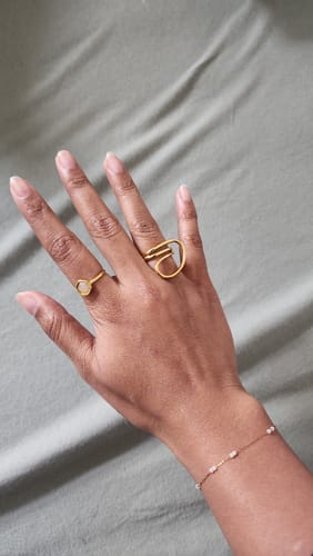 Reviewer's hand wearing the delicate Freya Crystal Hand Chain Bracelet alongside two gold-toned rings.