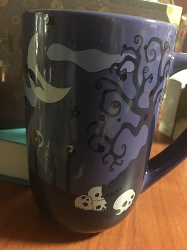 Reviewer's Haunted Colour Changing Nordic Mug featuring a dark blue design with spooky tree and skull illustrations.