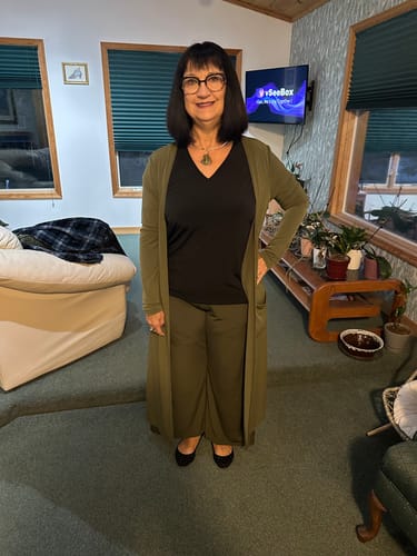 Customer's Habit Pants Petite worn with a matching long olive green cardigan and a black v-neck top.