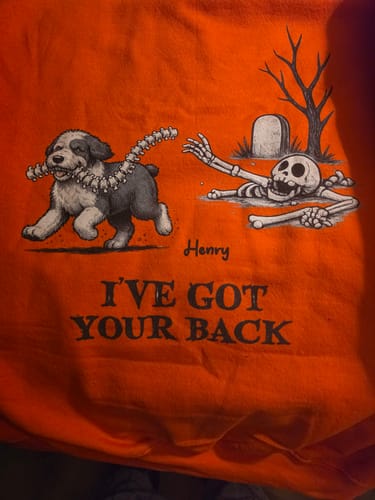 Customer's orange personalized I've Got Your Back shirt featuring a dog running with a spine and a skeleton.