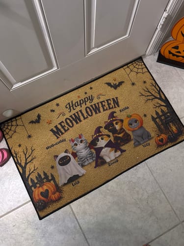 Customer's personalized Halloween doormat featuring four cute cats in costumes, placed at a front entryway.
