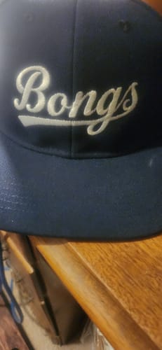 Customer's navy blue baseball cap with white cursive lettering reading Bongs.