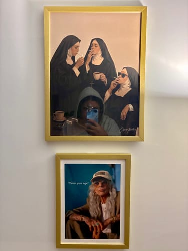 Customer's Out Of Office art print displayed in a gold frame, along with another art print on a light-colored wall.